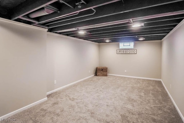 below grade area featuring carpet flooring and baseboards