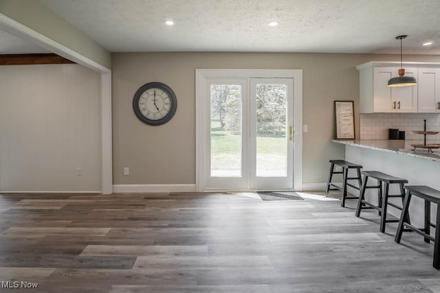 entryway featuring baseboards, wood finished floors, a textured ceiling, and recessed lighting