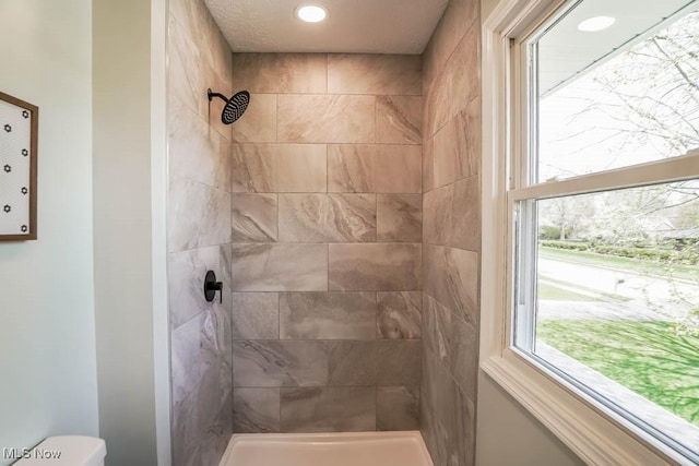 full bath featuring toilet and tiled shower