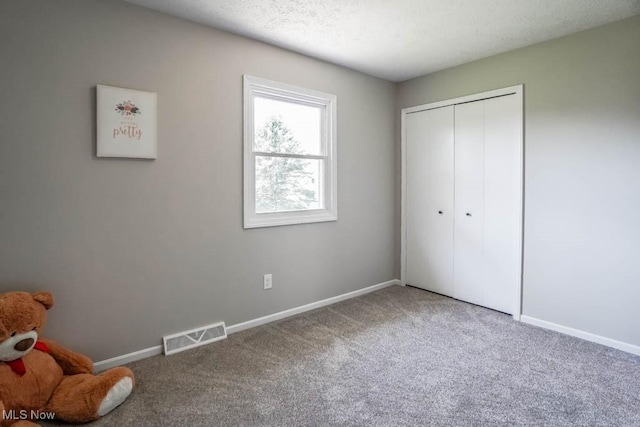 unfurnished bedroom featuring baseboards, visible vents, carpet floors, and a closet