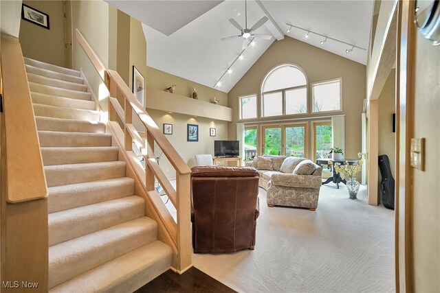 living area featuring stairway, high vaulted ceiling, ceiling fan, and rail lighting