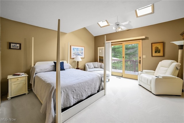 bedroom featuring carpet floors, a ceiling fan, access to exterior, and vaulted ceiling with skylight