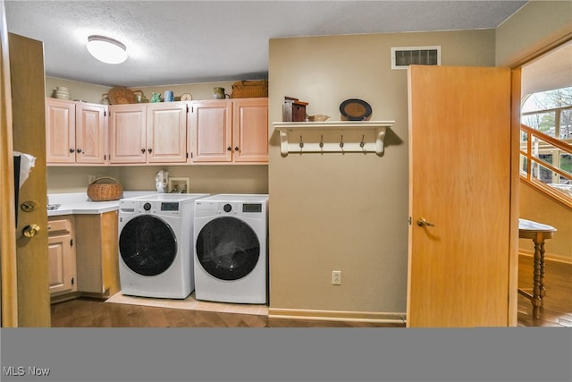 clothes washing area featuring visible vents, cabinet space, independent washer and dryer, and baseboards