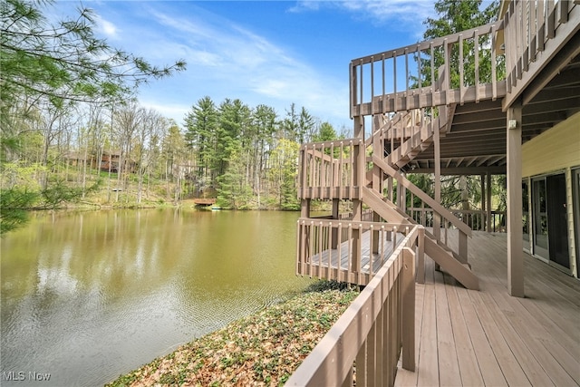 exterior space with a deck with water view and stairway