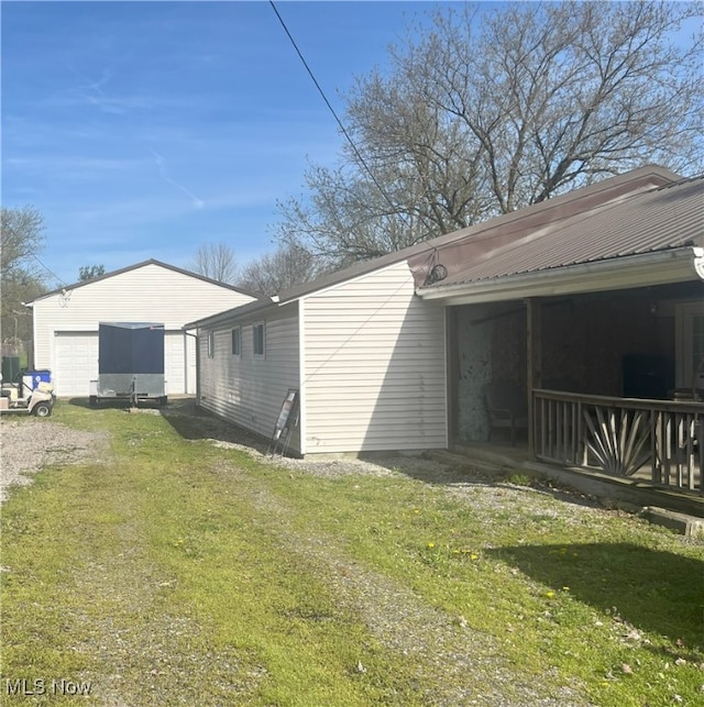 view of side of property featuring a garage, a lawn, and driveway