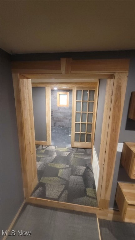doorway to outside featuring baseboards and carpet