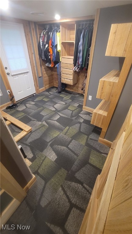 mudroom with dark carpet and baseboards
