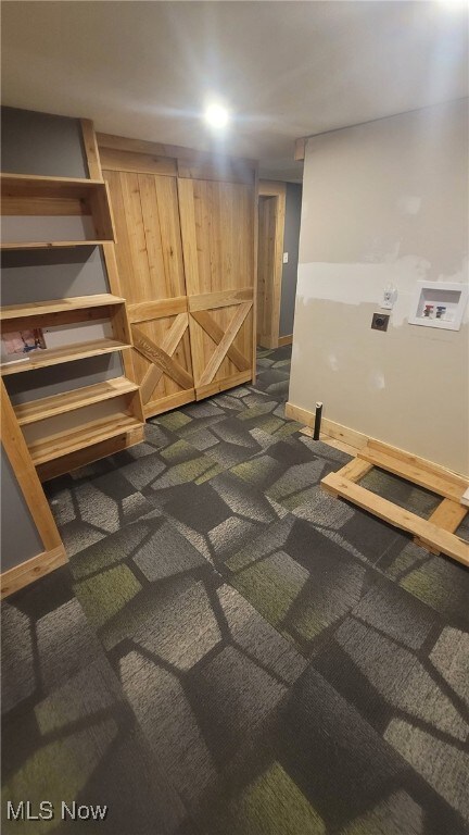 finished basement with baseboards and dark colored carpet