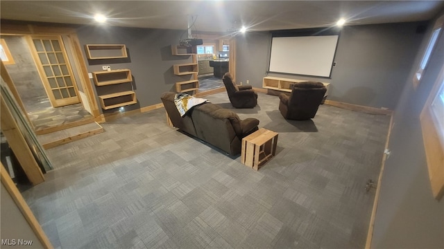 carpeted cinema room featuring baseboards