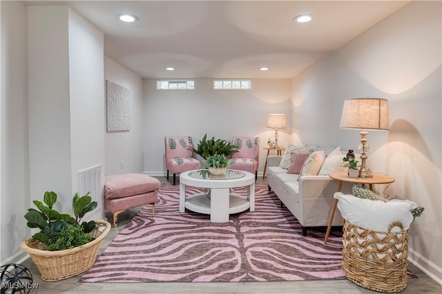 living area with baseboards, wood finished floors, visible vents, and recessed lighting