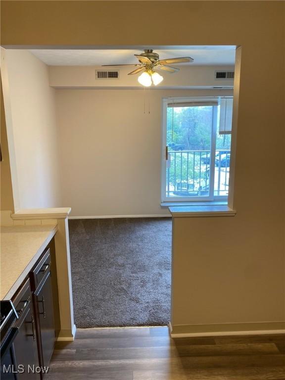 interior space with light countertops, a ceiling fan, visible vents, and baseboards