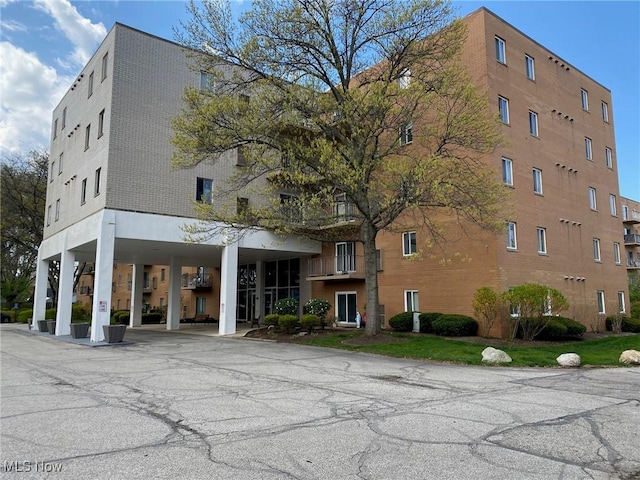 view of building exterior featuring driveway and a carport