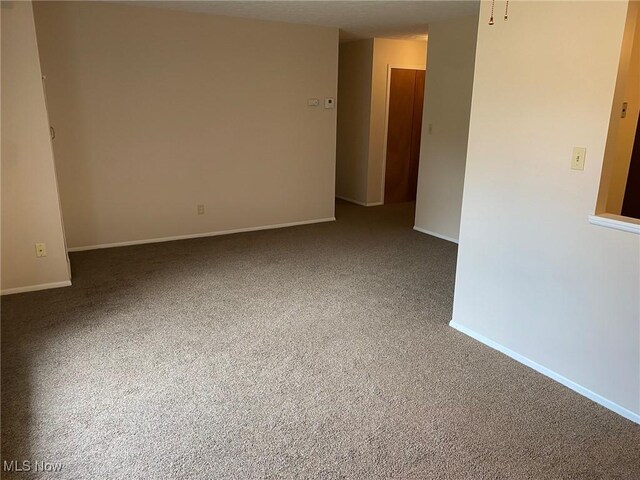 empty room with baseboards and carpet floors