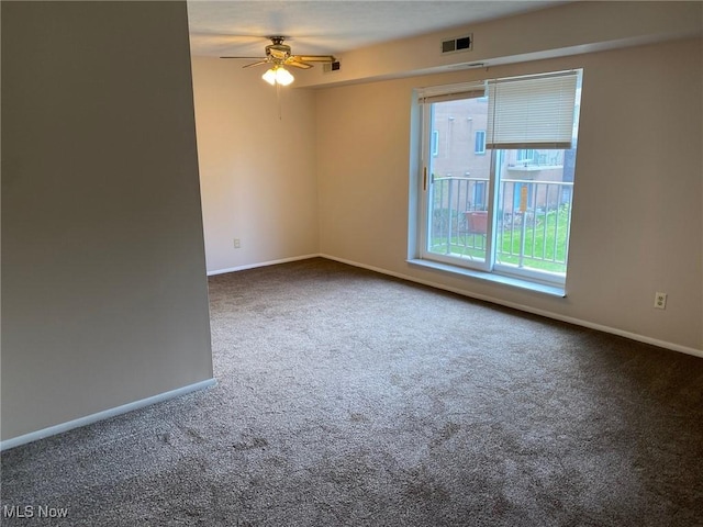 carpeted empty room with visible vents, baseboards, and ceiling fan
