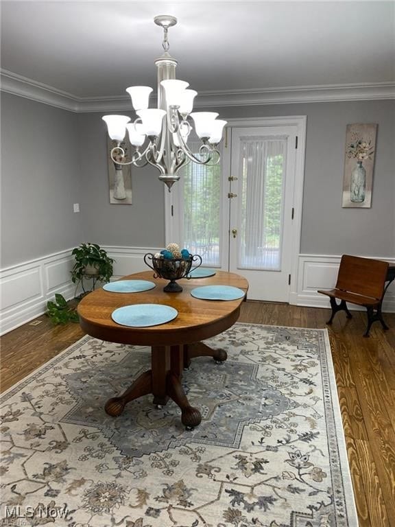 3016 Croydon Dr NW, Canton, OH 44718 - dining area with an inviting chandelier, crown molding, a wainscoted wall, and wood finished floors