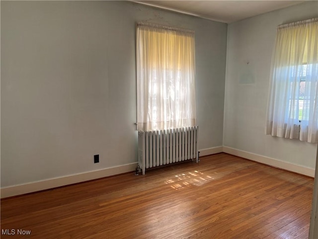 201 Gilcher Ct, Sandusky, OH 44870 - unfurnished room featuring baseboards, radiator heating unit, and hardwood / wood-style flooring