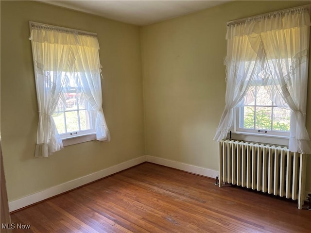 201 Gilcher Ct, Sandusky, OH 44870 - unfurnished room with radiator heating unit, wood finished floors, and a wealth of natural light