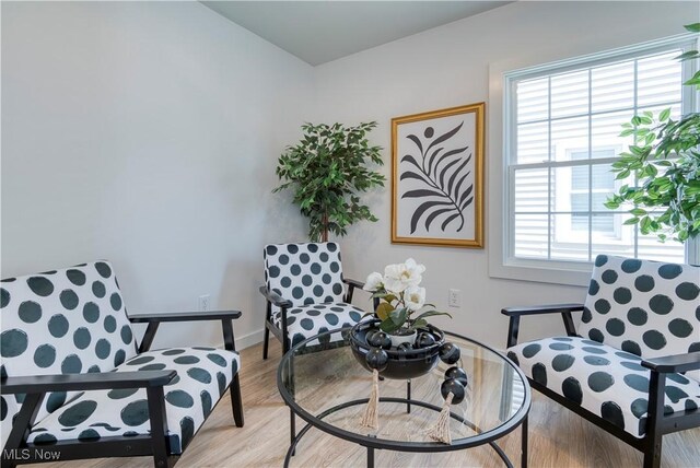 living area featuring light wood-style flooring and baseboards