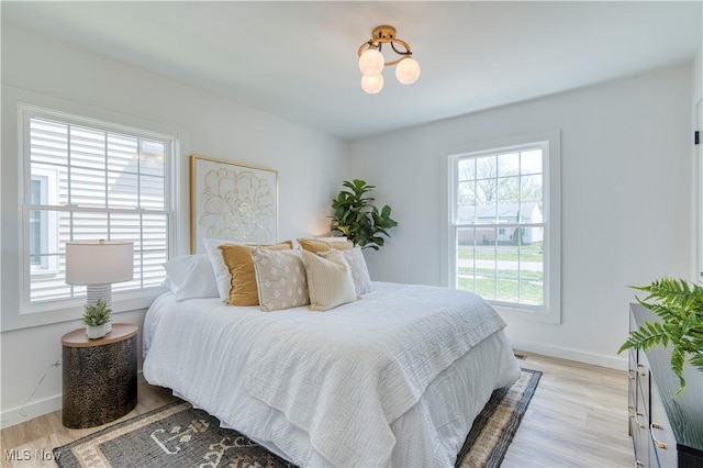 bedroom featuring light wood-style flooring and baseboards