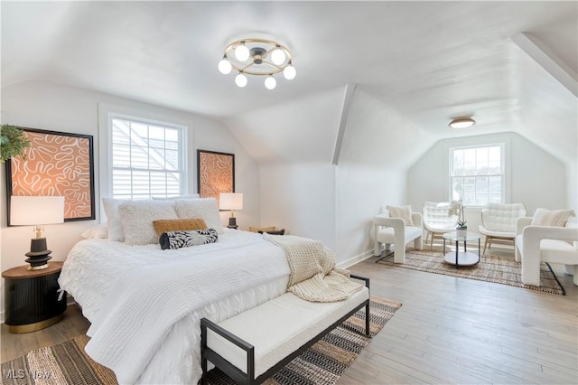 bedroom featuring lofted ceiling, wood finished floors, and baseboards
