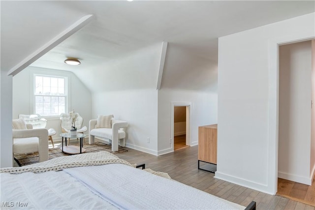 bedroom with lofted ceiling, wood finished floors, and baseboards