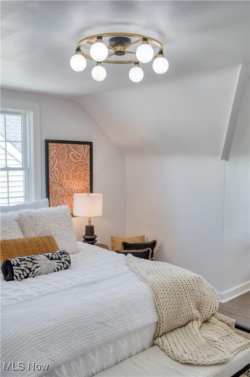 bedroom featuring lofted ceiling and wood finished floors