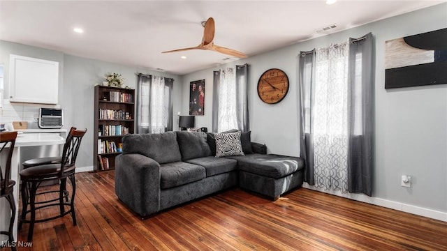 living area with a ceiling fan, visible vents, recessed lighting, and dark wood-type flooring