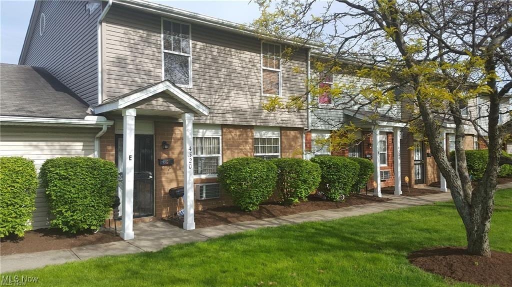 view of front of house with brick siding and a front lawn