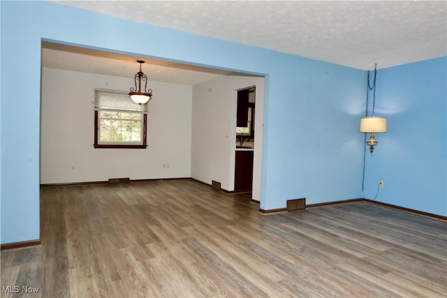4479 Azalea Ln, North Olmsted, OH 44070 - spare room with wood finished floors, a textured ceiling, and baseboards