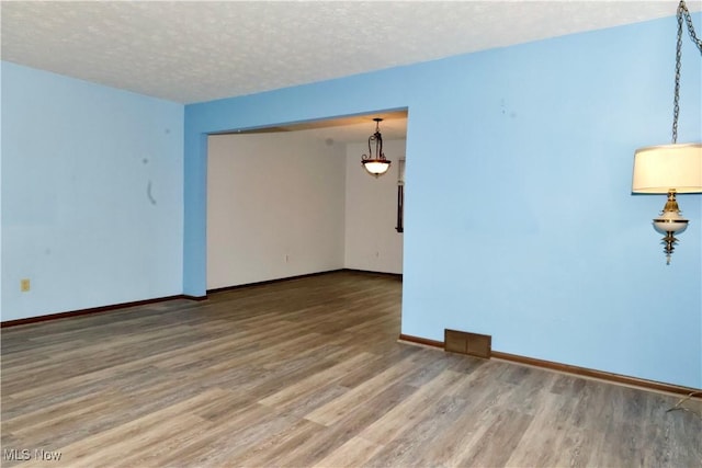 4479 Azalea Ln, North Olmsted, OH 44070 - empty room featuring baseboards, light wood-style floors, and a textured ceiling