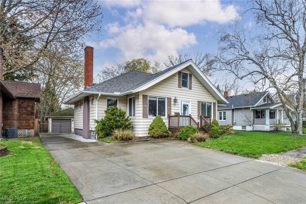 4108 W 217th St, Fairview Park, OH 44126 - bungalow featuring a chimney, an outdoor structure, roof with shingles, a front yard, and a garage