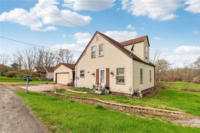 944 Bey Rd, Akron, OH 44312 - view of front facade featuring driveway, a front lawn, an outdoor structure, and a detached garage