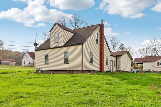 944 Bey Rd, Akron, OH 44312 - view of side of property with a chimney, a yard, and a shingled roof