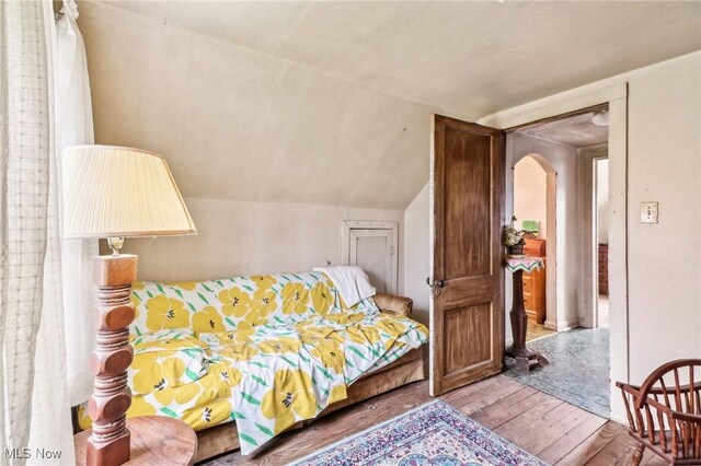 944 Bey Rd, Akron, OH 44312 - bedroom with wood-type flooring, arched walkways, and lofted ceiling