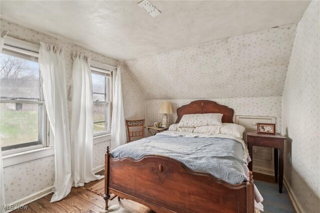 944 Bey Rd, Akron, OH 44312 - bedroom with wallpapered walls, wood finished floors, and vaulted ceiling