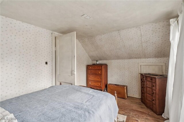 944 Bey Rd, Akron, OH 44312 - bedroom with wallpapered walls, wood finished floors, and vaulted ceiling