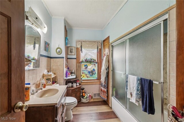 944 Bey Rd, Akron, OH 44312 - bathroom featuring vanity, tile walls, crown molding, wood finished floors, and enclosed tub / shower combo