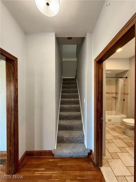 stairway featuring baseboards and wood finished floors