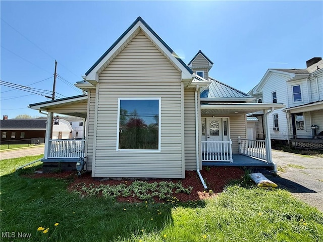 exterior space featuring a lawn and covered porch