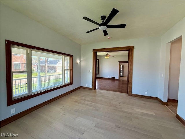 empty room with light wood-style floors, baseboards, and ceiling fan