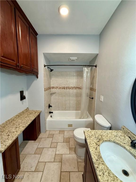 609 Main St, Toronto, OH 43964 - bathroom with toilet, shower / bath combo with shower curtain, stone tile floors, and vanity
