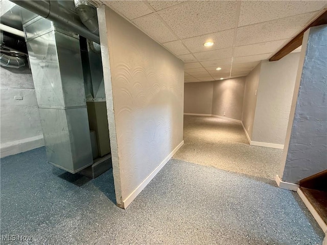 hall with speckled floor, a textured wall, baseboards, a paneled ceiling, and recessed lighting