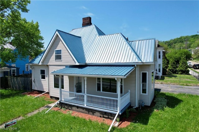 609 Main St, Toronto, OH 43964 - rear view of house featuring a porch, a chimney, metal roof, and a standing seam roof