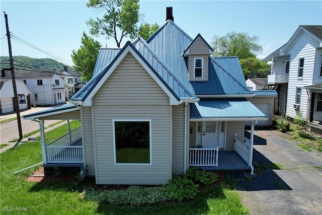 609 Main St, Toronto, OH 43964 - view of front of home featuring a porch, metal roof, and asphalt driveway