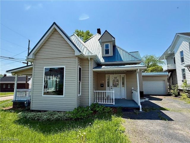 609 Main St, Toronto, OH 43964 - view of front facade featuring a porch, metal roof, driveway, a chimney, and a garage