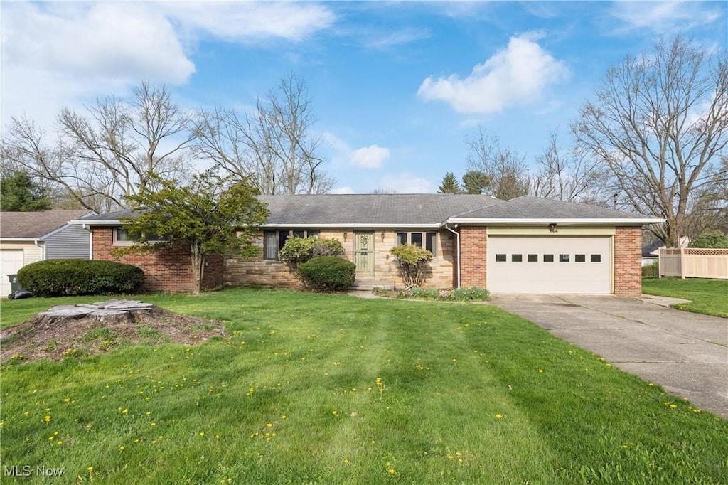 ranch-style home featuring brick siding, an attached garage, driveway, and a front lawn