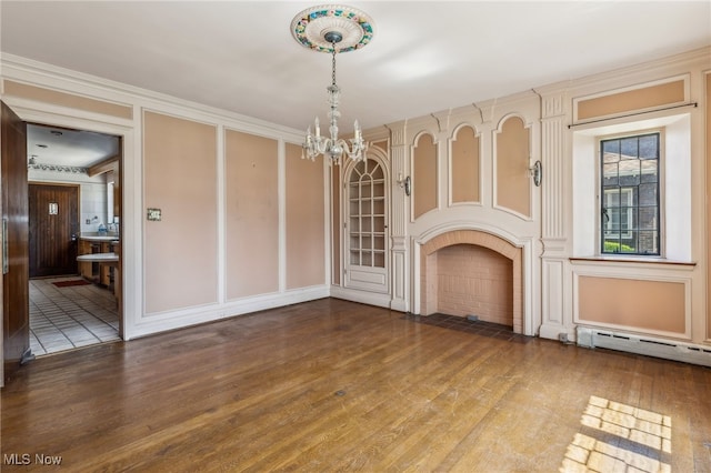 unfurnished living room featuring a fireplace with flush hearth, baseboard heating, wood finished floors, and a chandelier