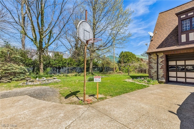 exterior space featuring concrete driveway and fence
