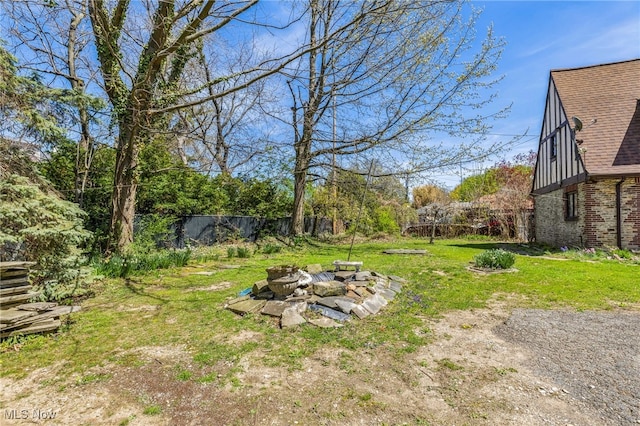 view of yard featuring fence and a fire pit