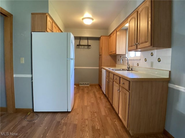 9083 Priem Rd, Strongsville, OH 44149 - kitchen with light countertops, a sink, white appliances, baseboards, and light wood-style flooring